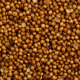 A close-up image featuring a large quantity of Evermill’s Organic Coriander Seeds Refill, sourced from Bulgaria. The seeds exhibit slight variations in shade, contributing to their natural, irregular appearance. The texture appears dry and slightly rough, true to the characteristics of whole coriander seeds that are often used in cooking and spices to enhance the flavor profile.